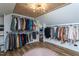 Spacious walk-in closet with wooden ceiling and a modern light fixture, with organized clothing racks and a circular rug at 8604 Timberwind Dr, Raleigh, NC 27615