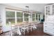 Dining room featuring large windows, dark wood floors, and a wooden dining table with seating for six at 8604 Timberwind Dr, Raleigh, NC 27615