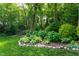 Beautiful garden featuring lush greenery, a variety of plants, and decorative rocks, creating a tranquil outdoor oasis at 8604 Timberwind Dr, Raleigh, NC 27615