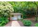 Charming garden shed surrounded by lush greenery and a quaint stone path at 8604 Timberwind Dr, Raleigh, NC 27615