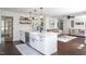 Bright kitchen with island, farmhouse sink, white cabinets, open shelves, and modern finishes at 8604 Timberwind Dr, Raleigh, NC 27615