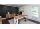 Well-lit office featuring dark accent wall, wood floors, a large desk, and plenty of natural light for a productive workspace at 8604 Timberwind Dr, Raleigh, NC 27615