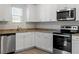 Modern kitchen featuring stainless steel appliances, granite countertops, and sleek white cabinetry at 87 Royal Meadow Dr, Angier, NC 27501