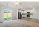 Open-concept living space with a sliding glass door, modern kitchen, and plush carpet at 87 Royal Meadow Dr, Angier, NC 27501