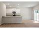 A well lit kitchen with white cabinets, granite countertops, and stainless steel appliances at 94 Taverners Ln, Angier, NC 27501
