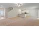 Open-concept living room with plush carpeting, white walls, and a staircase at 94 Taverners Ln, Angier, NC 27501