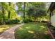 Spacious back yard with stone walkway and decorative trellis at 944 Athens Dr, Raleigh, NC 27606