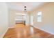Bright dining room with hardwood floors, modern light fixture, and access to the kitchen at 944 Athens Dr, Raleigh, NC 27606