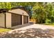 Two-car garage and ample driveway space surrounded by lush greenery at 944 Athens Dr, Raleigh, NC 27606