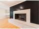 Living room showcasing a tile fireplace, black accent wall, and beautiful hardwood floors at 944 Athens Dr, Raleigh, NC 27606
