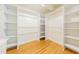 Spacious walk-in closet with custom shelving and hardwood floors at 944 Athens Dr, Raleigh, NC 27606