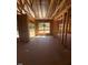 Living room under construction with exposed wood framing, and window views at 95 Bald Cypress Ln, Youngsville, NC 27596