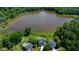 Stunning aerial view of home on the lake, surrounded by lush trees, offering serene and private living at 9701 Corktree Ct, Wake Forest, NC 27587