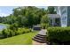 A private backyard features a wooden deck with a hot tub and lush landscaping overlooking the water at 9701 Corktree Ct, Wake Forest, NC 27587