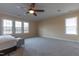 Spacious carpeted bedroom with ceiling fan, neutral walls, and plenty of natural light from large windows at 9701 Corktree Ct, Wake Forest, NC 27587