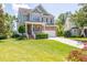 Two-story home boasts stone accents, a covered porch, attached garage, and lush lawn at 9701 Corktree Ct, Wake Forest, NC 27587