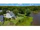 An aerial view of the home's rear, featuring a landscaped yard, deck, and access to a serene lake at 9701 Corktree Ct, Wake Forest, NC 27587