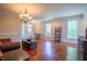 Bright living room featuring hardwood floors, large windows, and a stylish chandelier at 9701 Corktree Ct, Wake Forest, NC 27587