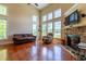 Spacious living room featuring a stone fireplace, large windows, and hardwood floors at 9701 Corktree Ct, Wake Forest, NC 27587