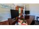 Large office space with a wooden desk, wainscotting, and hardwood floors at 9701 Corktree Ct, Wake Forest, NC 27587
