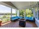 Screened-in porch featuring a sectional couch with blue cushions and a fire table at 9701 Corktree Ct, Wake Forest, NC 27587