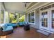 Screened porch with blue cushioned seating, fire table, ceiling fan and door at 9701 Corktree Ct, Wake Forest, NC 27587