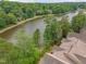Aerial view showcases multi-story waterfront homes with lush trees, a lake, and a winding walking path at 0317 Glen Echo Ln # C, Cary, NC 27518