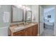 Bathroom with double vanity, granite countertop, decorative mirrors, and view into the bedroom at 0317 Glen Echo Ln # C, Cary, NC 27518