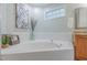 Bathroom with granite-topped vanity, soaking tub, and garden window at 0317 Glen Echo Ln # C, Cary, NC 27518