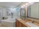 Bathroom featuring dual sinks, granite countertops, large soaking tub, and walk in shower at 0317 Glen Echo Ln # C, Cary, NC 27518