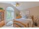 Cozy bedroom with a large arched window, ceiling fan, and warm natural light at 0317 Glen Echo Ln # C, Cary, NC 27518