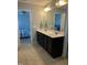 Bathroom with a double vanity, dark cabinetry, and bright lighting above a large mirror at 109 E Webber Lane Ln, Clayton, NC 27527