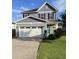 Charming two-story home featuring a two-car garage, manicured lawn, and inviting turquoise front door at 109 E Webber Lane Ln, Clayton, NC 27527