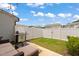 Backyard patio with a grill and cozy seating, surrounded by a well-maintained yard and white fence at 1137 Amber Shadow Dr, Durham, NC 27703