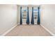 A bright bedroom with two windows adorned with dark blue curtains and neutral walls at 1137 Amber Shadow Dr, Durham, NC 27703