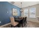 Dining room with blue accent wall, modern light fixture, and natural light from a large window at 1137 Amber Shadow Dr, Durham, NC 27703