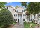 Inviting two-story condo with a light yellow exterior, black shutters, and landscaped front yard at 117 Scott Ln, Chapel Hill, NC 27514
