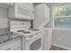 Appliances in kitchen including a microwave, oven, cooktop, and washer and dryer unit at 117 Scott Ln, Chapel Hill, NC 27514