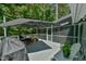 Back deck featuring an umbrella, table, chairs and grill with screening on the sides at 1205 Hillsborough Rd, Chapel Hill, NC 27516