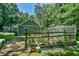 Well-kept backyard garden with a greenhouse and different plants surrounding the area at 1205 Hillsborough Rd, Chapel Hill, NC 27516