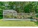 Backyard garden with raised garden beds and a greenhouse, all surrounded by a wooden fence at 1205 Hillsborough Rd, Chapel Hill, NC 27516