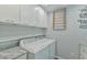 Well-equipped laundry area with a washer, dryer, cabinets, and overhead storage at 1205 Hillsborough Rd, Chapel Hill, NC 27516