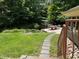 Lush backyard featuring a stone pathway, dining area, and a serene forested backdrop at 1320 Shepherd St, Durham, NC 27707