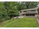 Landscaped backyard with a lush lawn, solar panels, outdoor dining, and a quaint stream for serene outdoor living at 1320 Shepherd St, Durham, NC 27707