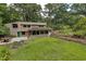 Expansive backyard featuring a well-maintained lawn, retaining walls, and a gravel patio with outdoor seating at 1320 Shepherd St, Durham, NC 27707