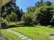 Lush backyard with stone steps leading to a verdant lawn surrounded by mature trees and landscaping at 1320 Shepherd St, Durham, NC 27707