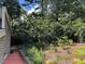 Landscaped backyard with lush greenery and plants, complemented by a charming brick walkway and mature trees at 1320 Shepherd St, Durham, NC 27707