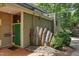 Inviting home exterior with solar panels, green front door, and unique artistic metal scrap decorations at 1320 Shepherd St, Durham, NC 27707