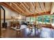Spacious living room with a wood-beamed ceiling, fireplace, unique carved chairs, and expansive windows at 1320 Shepherd St, Durham, NC 27707