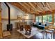 Inviting living space featuring a wood stove, comfortable seating, and rustic exposed beam ceiling at 1320 Shepherd St, Durham, NC 27707